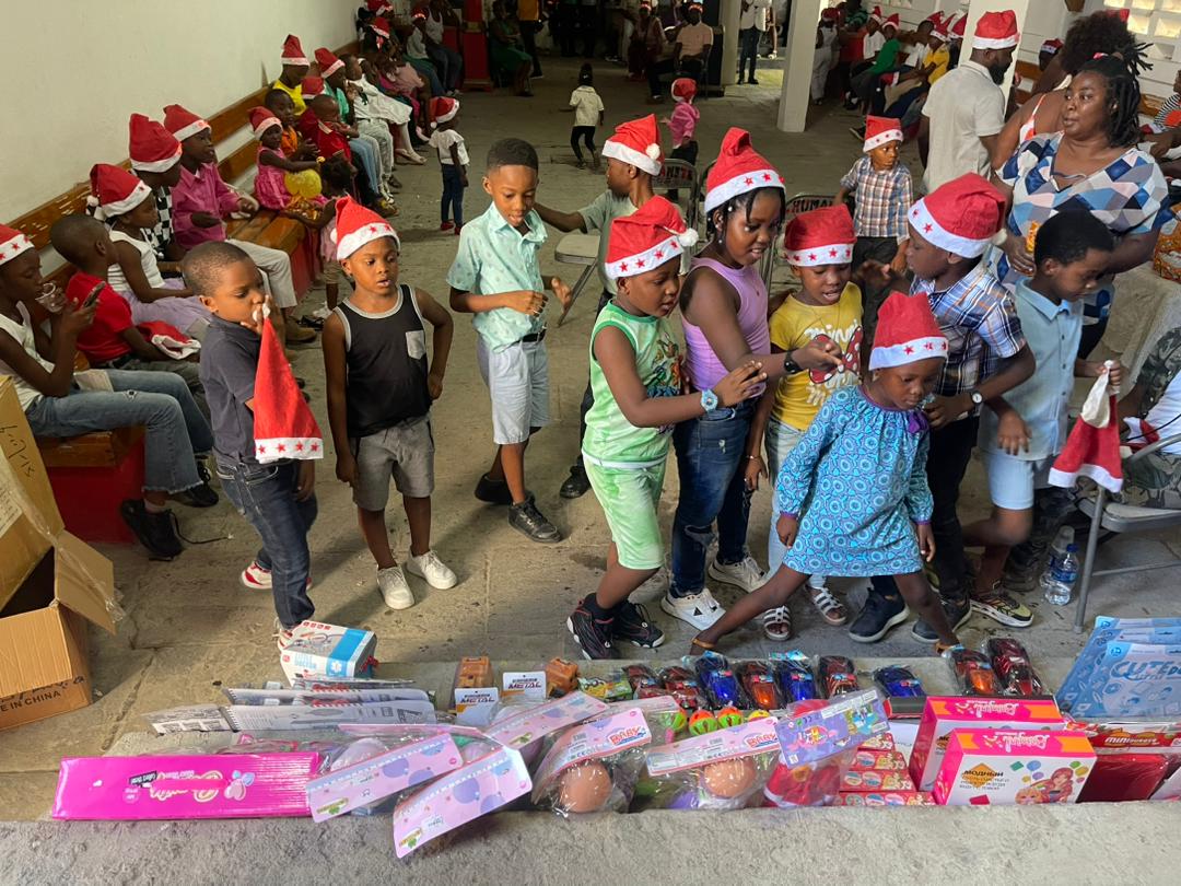 Children gathered around donated educational toys and gifts